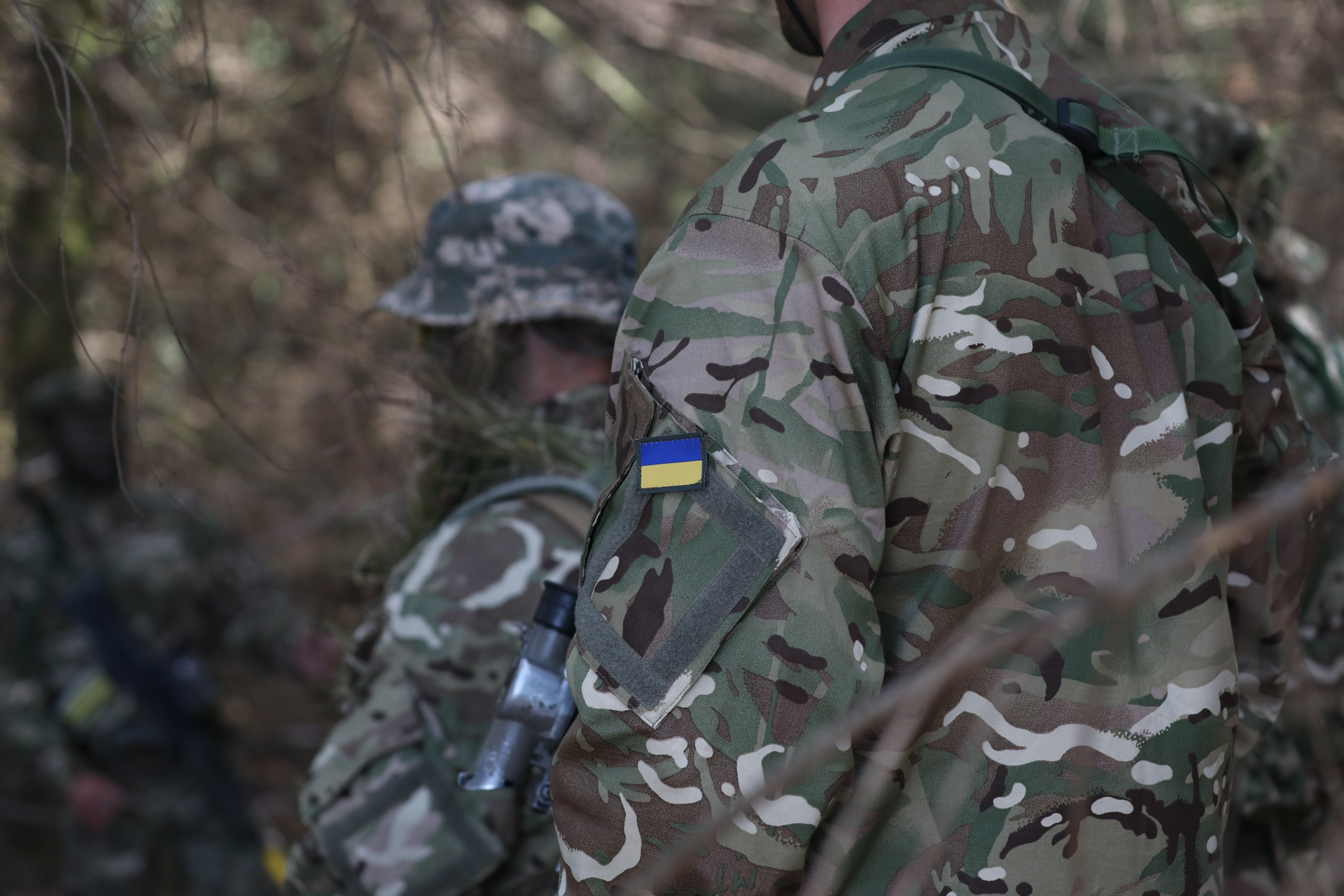 Image shows Ukrainian soldiers in camouflage uniform.